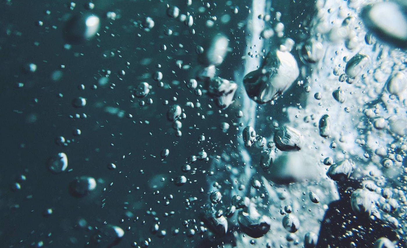 Wassertropfen an einer Oberfläche – Sinnbild für einen frischen Wasserschaden.